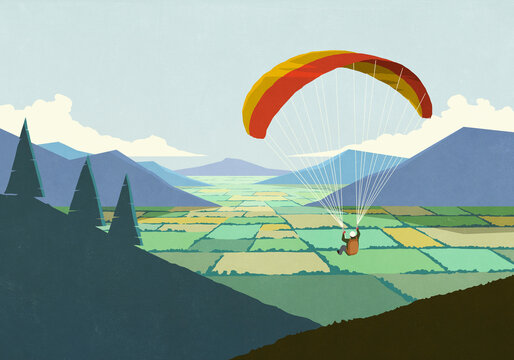 Parachuter descending over scenic rural mountain valley landscape
