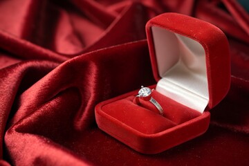 single diamond ring in a red velvet case 