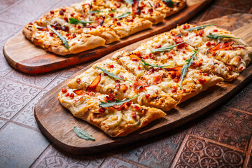 Traditional French dish tarte flambee cream cheese, bacon and onions. Flammkuchen from Alsace region.