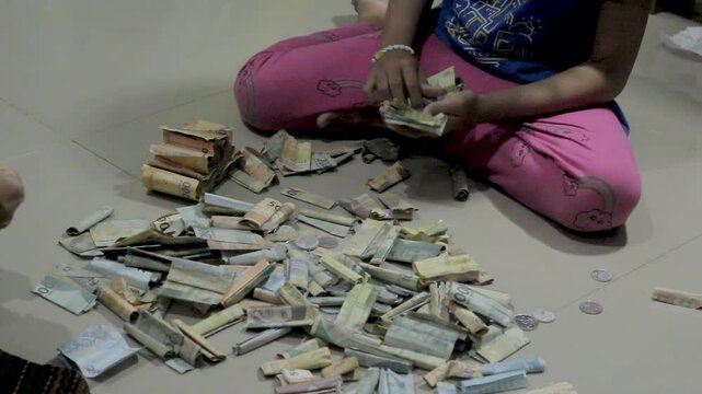 a Child Compiles and Calculates Money from a Piggy Bank, Family Savings Concept, Saving Traditions 