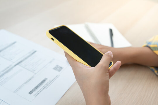 business man use phone to scan barcode or QR codes to pay credit card bill after receiving document invoice online. payment, receive, paying electricity, digital payments without money, technology - Powered by Adobe