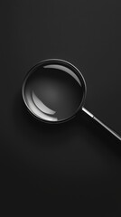 Close-up of a black magnifying glass on a dark background.