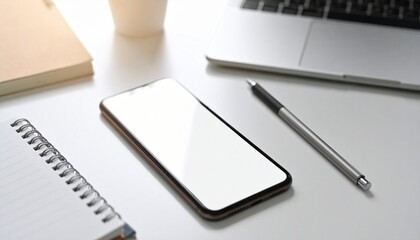 Smartphone mockup with clean blank dcreen, placed on desk beside notepad and pen