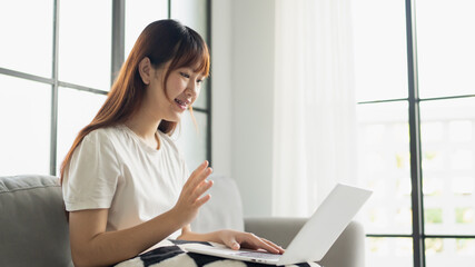 Asian woman in casual sitting using laptop