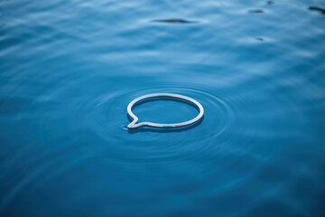 Tranquil Silver Speech Bubble Floating on Calm Blue Waters Reflecting Peaceful Serenity