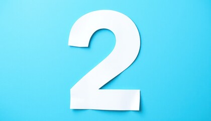 White cutout number two on light blue surface