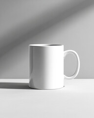 Obraz premium Blank white enameled mug ready for custom design on grey tabletop with natural light shadow
