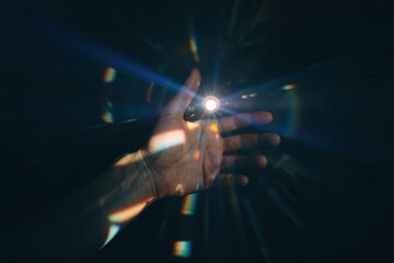 Illuminated Hand Reaching Out with Light Rays Creating a Mystical Atmosphere