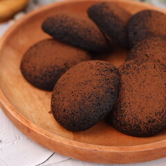 Chocolate steamed bakpia on a wooden plate and selected ornaments and background