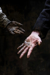 two hands reaching out - one clean and well-dressed