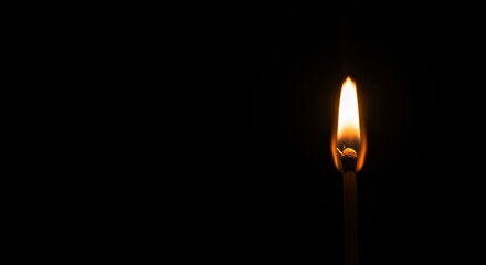 Single match flame against black background