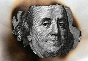 burning dollar bill as a symbol of inflation and the financial crisis in United States of America. Horizontal macro image.