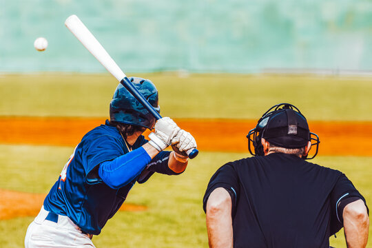 Baseball action, baseball player with bat waiting for ball with umpire, rear view. Team sports - Powered by Adobe