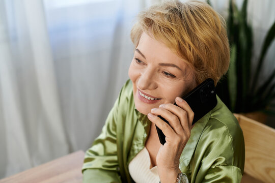 Beautiful senior woman enjoying a cheerful conversation on the phone in her cozy home