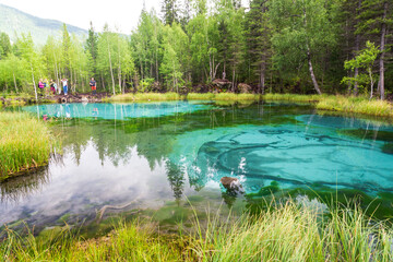 Altai republic, Russia - 26 July 2020: Tourists at Geyser blue lake in which fountains at the bottom color blue circles in the vicinity of the village Aktash, Altai Mountains