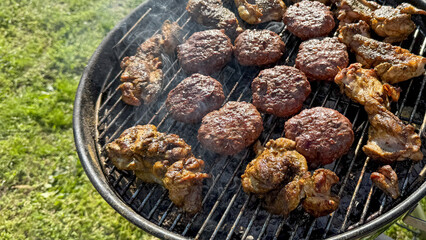 Juicy burgers and chicken grilling on barbecue, summer outdoor cooking, Independence Day...