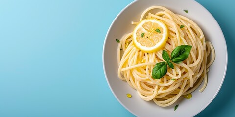 Spaghetti aglio e olio with lemon and basil on blue background