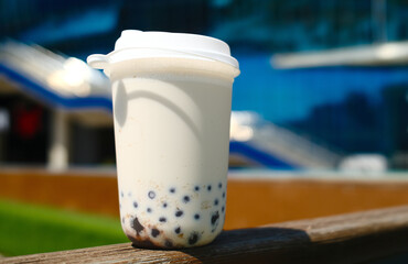 Milk bubble tea in plastic cup with blurred background