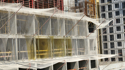 concrete building under construction with safety nets, industrial development, construction site engineering