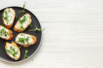 Healthy snack - sandwiches with microgreens on plate, top view