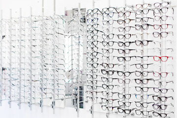 Row of various glasses and frames at an opticians shop. Stand with glasses in optics store