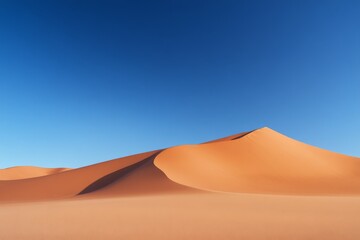 Vast expanse of orange sand dunes under a clear blue sky.