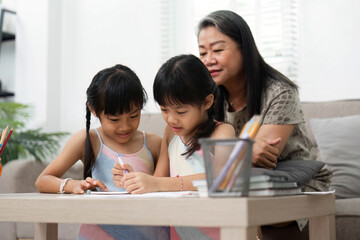 Learning and Family Bonding. Two young girls engage in creative activities while their grandmother...