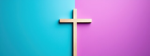 A wooden cross is placed on a blue and pink background
