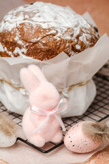 Easter celebration composition with traditional cake, pastel speckled eggs and decorative pink bunny. Spring holiday scene...