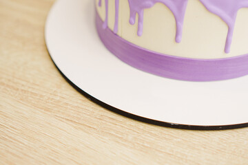 A fragment of a cake decorated with streaks of purple icing.