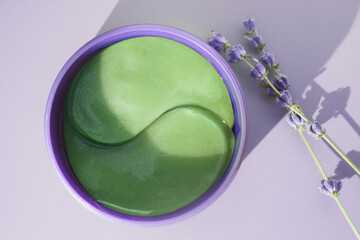 Cosmetic product green glitter lavender eye patches in plastic jar. Lavender flowers.