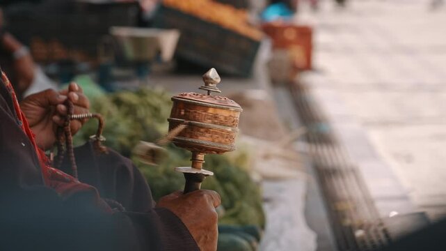 Close-Up of Hand Spinning Tibetan Prayer Wheel