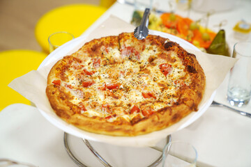 close-up. A large margherita pizza on the table with appetizers for the holiday.