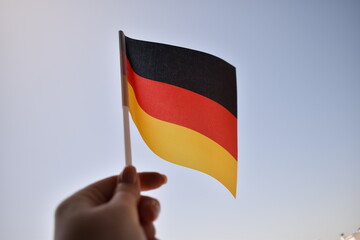 German national flag flying against blue sky – symbol of patriotism, unity, and the cultural and historical identity of Germany. Ideal for national holidays or international themes.