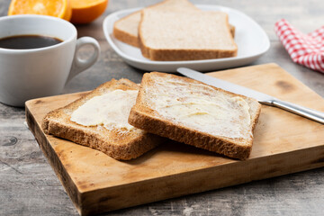 Sliced fresh bread and butter on wooden table