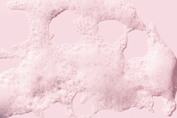 Cosmetic cleansing washing pink soapy foam gel on pink isolated background. Skin care texture