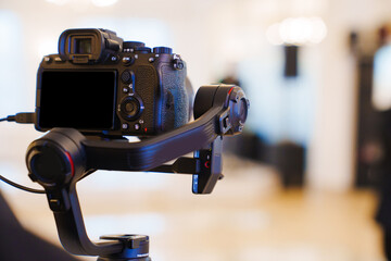 A professional camera on the blurred background of a banquet hall. 