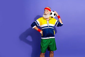 Elderly man in retro sportswear smiling with a soccer ball, embracing a fitness and active lifestyle with a vintage vibe.