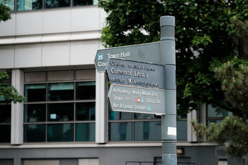 Leeds UK: 4th June 2024: A directional sign in Leeds, pointing towards significant locations like the Town Hall, library, cathedral, and art gallery