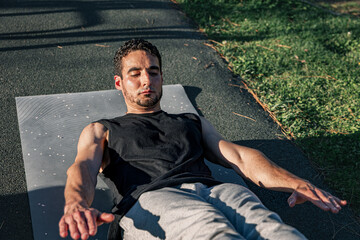 Man holding static hollow body position on outdoor exercise mat, showcasing abdominal tension,...