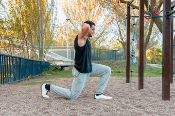Man performing bodyweight lunge with hands behind head outdoors, targeting leg strength, posture,...