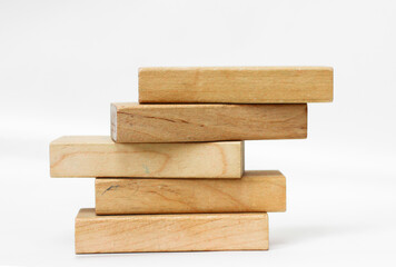 A pile of five wooden blocks on the soft white background.