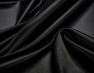 Fototapeta premium A luxurious black silk fabric drapes elegantly, showcasing its smooth texture and subtle sheen, perfect for high-end fashion or sophisticated decor.