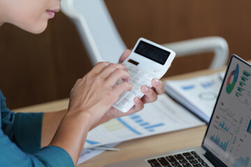 Business professional analyzing data with calculator and laptop