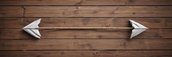 Fototapeta premium Two paper arrows, opposite directions, on wooden background, pathway, paper