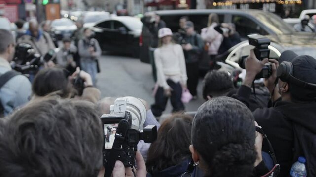 Paparazzi photographing famous person arriving by car