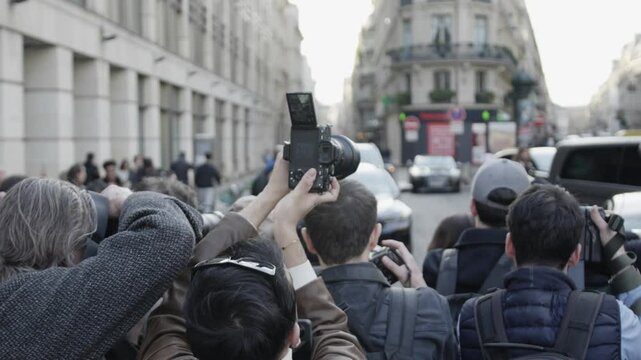 Paparazzi taking photos of celebrity in paris street