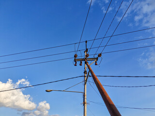 Electric utility pole with multiple cables stretching across a clear sky, symbolizing connectivity and modern infrastructure.
