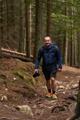 Photographer hiking uphill through forest trail