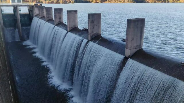 A dam located in southern Spain, filled to capacity, begins to release its water with a deafening sound due to the force of the abundant amount of water falling per second.